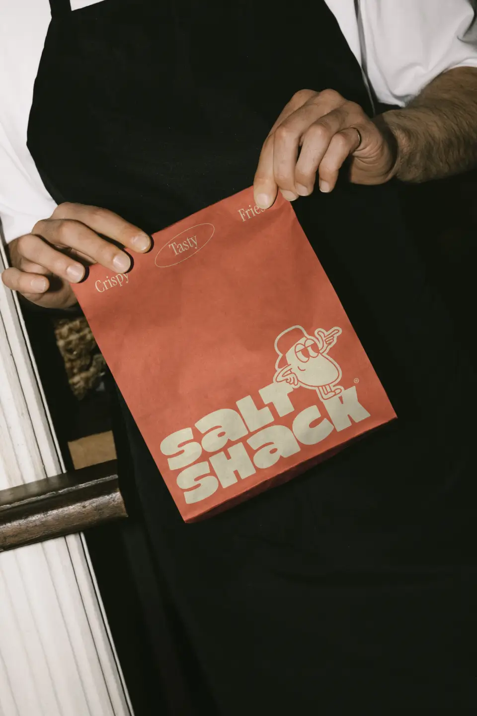 Employé de chez Salt Shack avec un sac à emporter